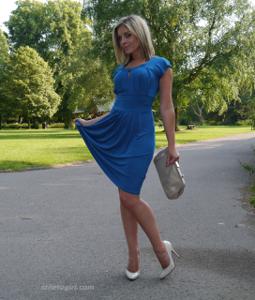 Привлекательная мамка в синем платье позирует на улице - фото #2