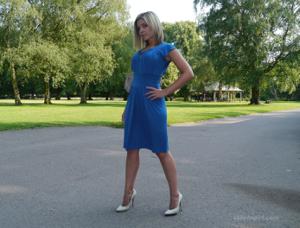 Привлекательная мамка в синем платье позирует на улице - фото #3