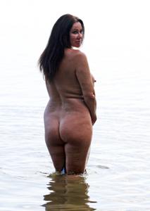 Полная женщина с широкой жопой позирует без купальника на берегу озера - фото #12