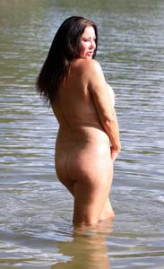 Полная женщина с широкой жопой позирует без купальника на берегу озера - фото #24